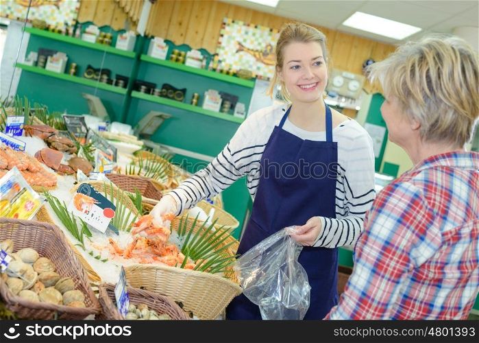 smiling woman shopping in supermarket department of fruits