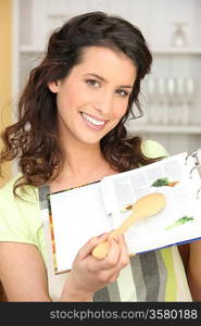 Smiling woman showing cookbook