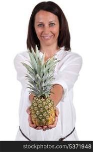 Smiling woman showing pineapple