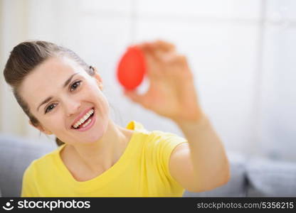 Smiling woman showing red Easter egg