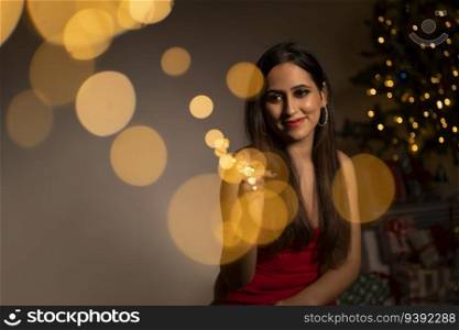 Smiling Woman Sitting At Home Near Christmas Tree
