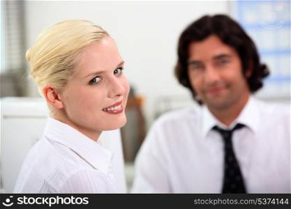 Smiling woman sitting with a colleague
