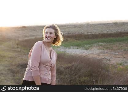 Smiling woman standing in wheat field