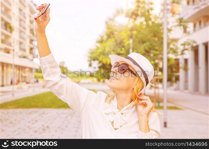 smiling woman taking selfie in a sunny day