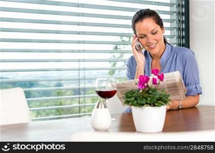 Smiling woman talking mobile phone relaxing reading home living room