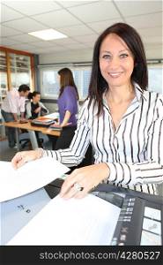 Smiling woman using a photocopier