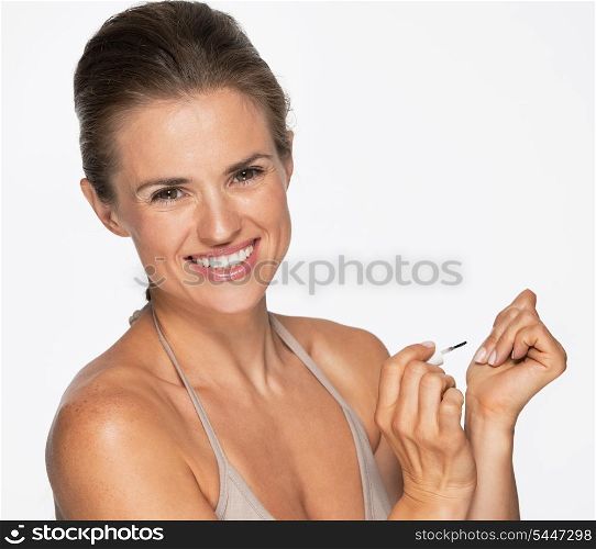 Smiling woman using nail polish