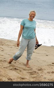 Smiling Woman Walking Barefoot on Beach