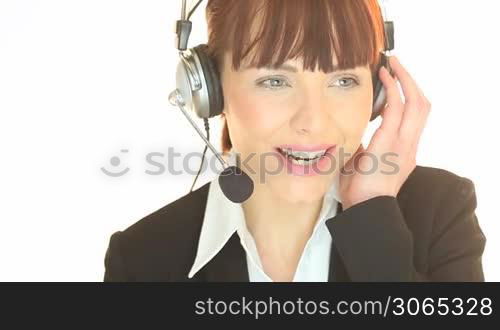 Smiling woman wearing headphones listening to a call in a customer service concept