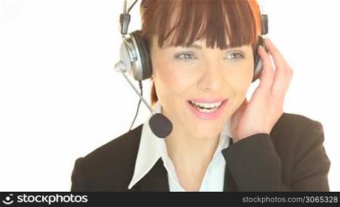 Smiling woman wearing headphones listening to a call in a customer service concept