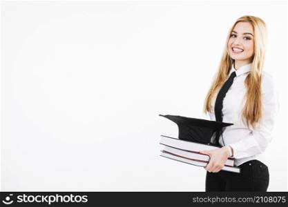 smiling woman with books mortarboard