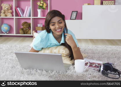 Smiling woman with credit card shopping online at home