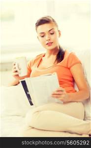 smiling woman with cup of coffee reading magazine at home