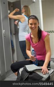 Smiling woman with friend in background at gym&rsquo;s locker room