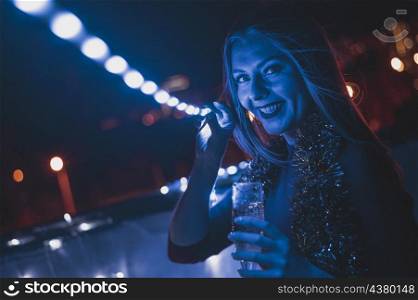 smiling woman with glass champagne blue lamps