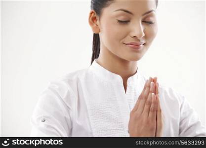 Smiling woman with hands clasped practicing yoga