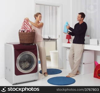 smiling woman with man dooing laundry with washing machine