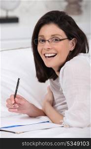 Smiling woman with notebook and pencil