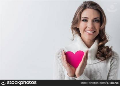 Smiling woman with paper heart. Happy young smiling woman with pink paper heart