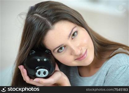 Smiling woman with piggy bank