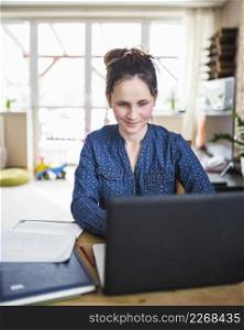 smiling woman working laptop home