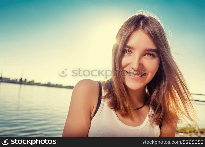 Smiling women looking at camera closeup shot. Beautiful girl on the beach alone