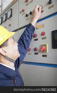 Smiling worker checking controls in a gas plant, Beijing, China