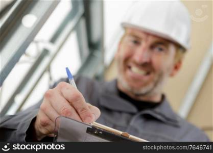 smiling worker showing a clipboard