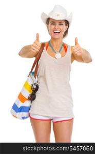 Smiling young beach woman in hat showing thumbs up