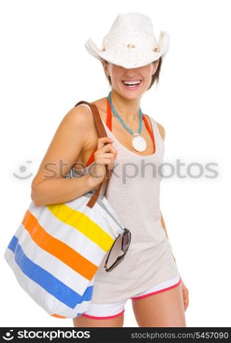 Smiling young beach woman with hat pulled over eyes