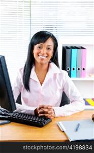 Smiling young black business woman at desk in office