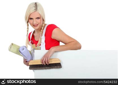 Smiling young blonde preparing to wallpaper a room