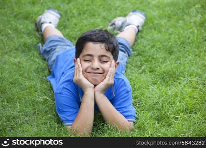 Smiling young boy lying on grass