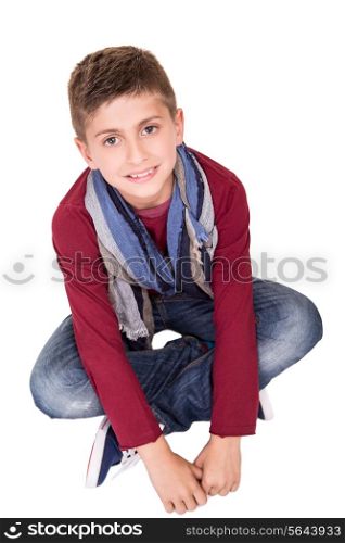 Smiling young boy sitting over white background