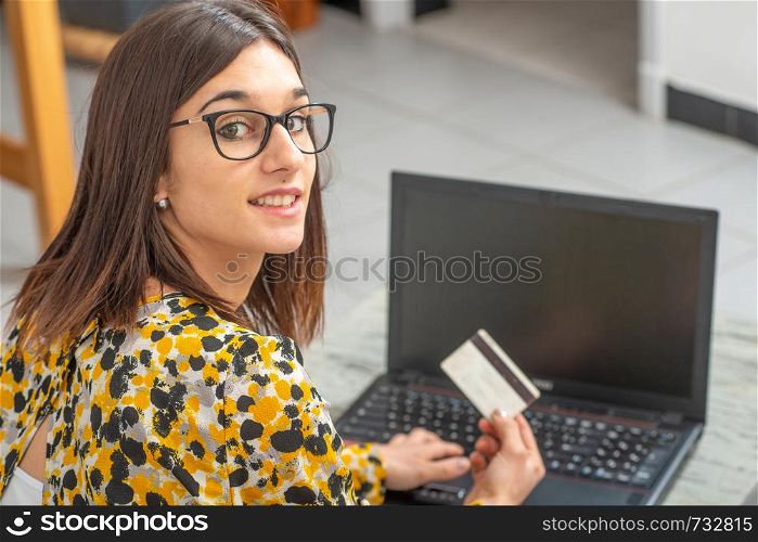 smiling young brunette woman buying with internet