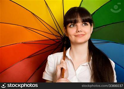 smiling young brunette woman in white blouse with multi-coloured umbrella