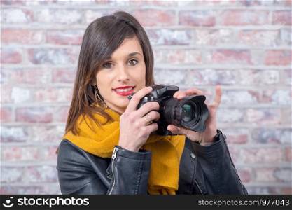 smiling young brunette woman with a photographic camera
