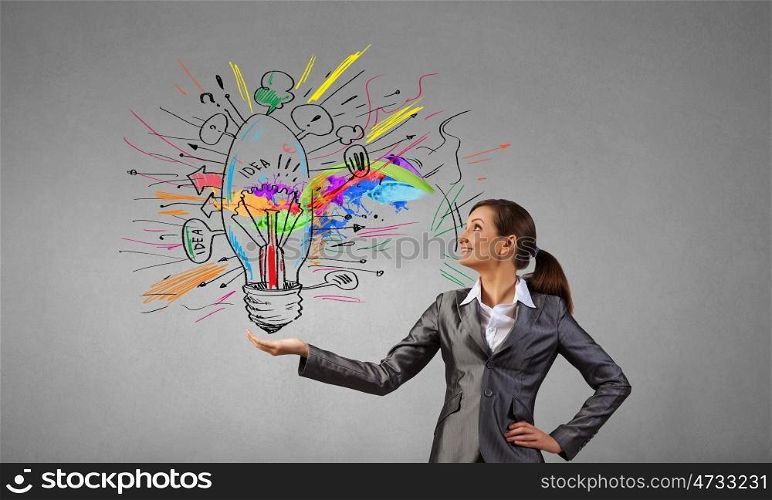 Smiling young businesswoman holding light bulb in palm. Present your idea