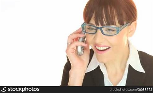 Smiling young businesswoman in glasses listening to good news on her mobile phone