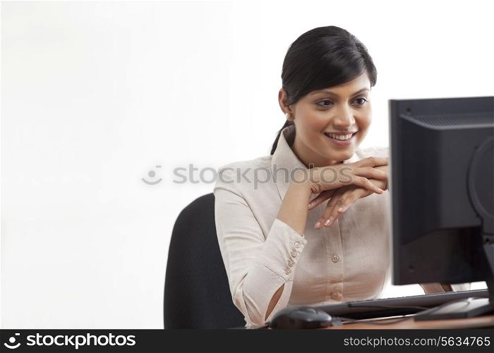 Smiling young businesswoman looking at computer