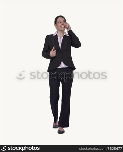 Smiling young businesswoman on the phone, full length, studio shot