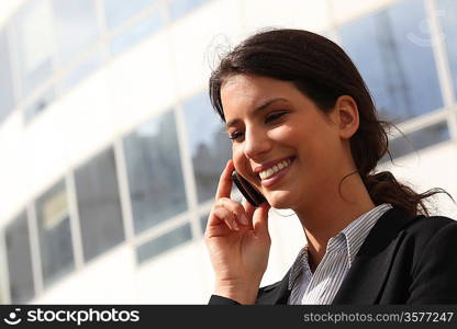 Smiling young businesswoman using a cellphone