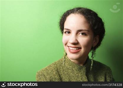 Smiling young Caucasian woman on green background wearing green clothing.