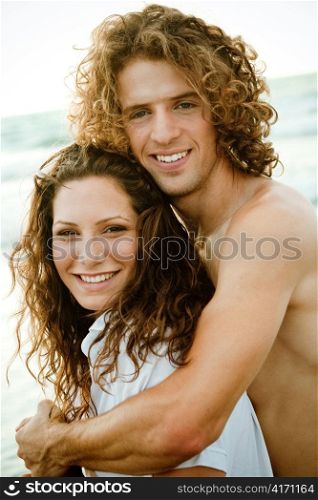 Smiling young couple by the beach