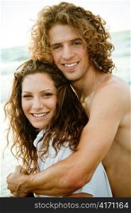 Smiling young couple by the beach