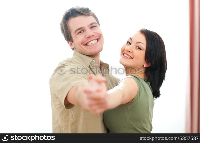 Smiling young couple dancing at home