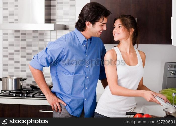 smiling young couple enjoying their love in kitchen