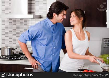 smiling young couple enjoying their love in kitchen