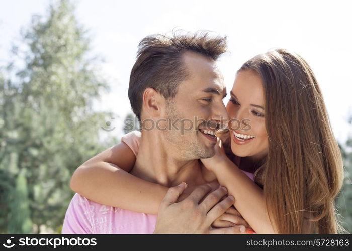 Smiling young couple looking at each other in park