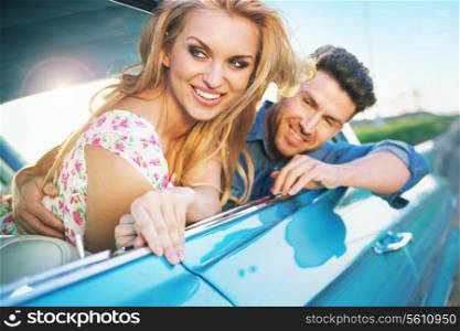 Smiling young couple resting in the retro car